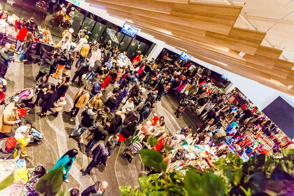 A large group of people are standing in a large room.