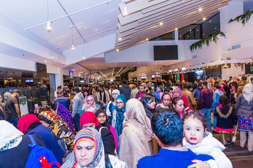 A crowd of people are gathered in a large room.