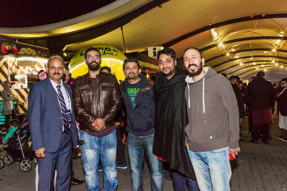 A group of men are posing for a picture in front of a food truck.