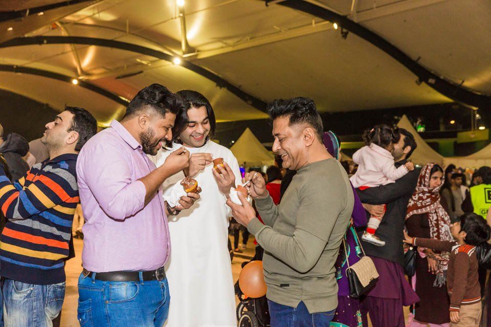 A group of men are eating food at a party.
