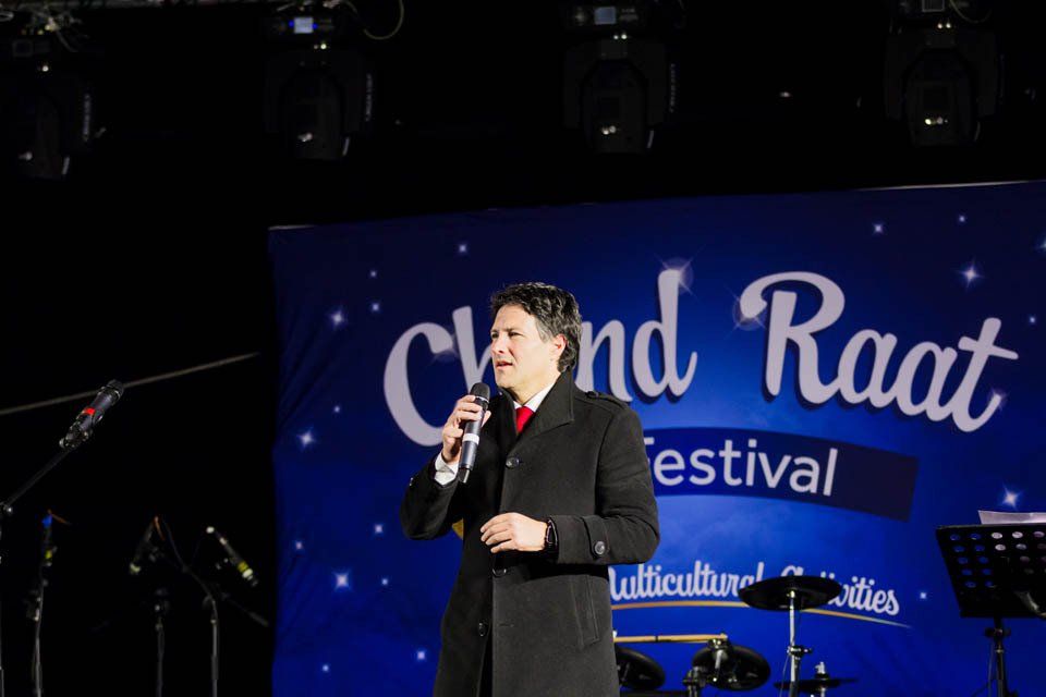 A man is standing on a stage holding a microphone.