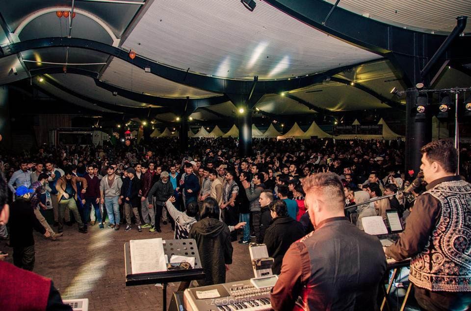 A group of people are playing instruments in front of a large crowd.