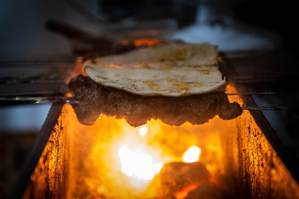 A tortilla is being cooked on a grill over a fire.