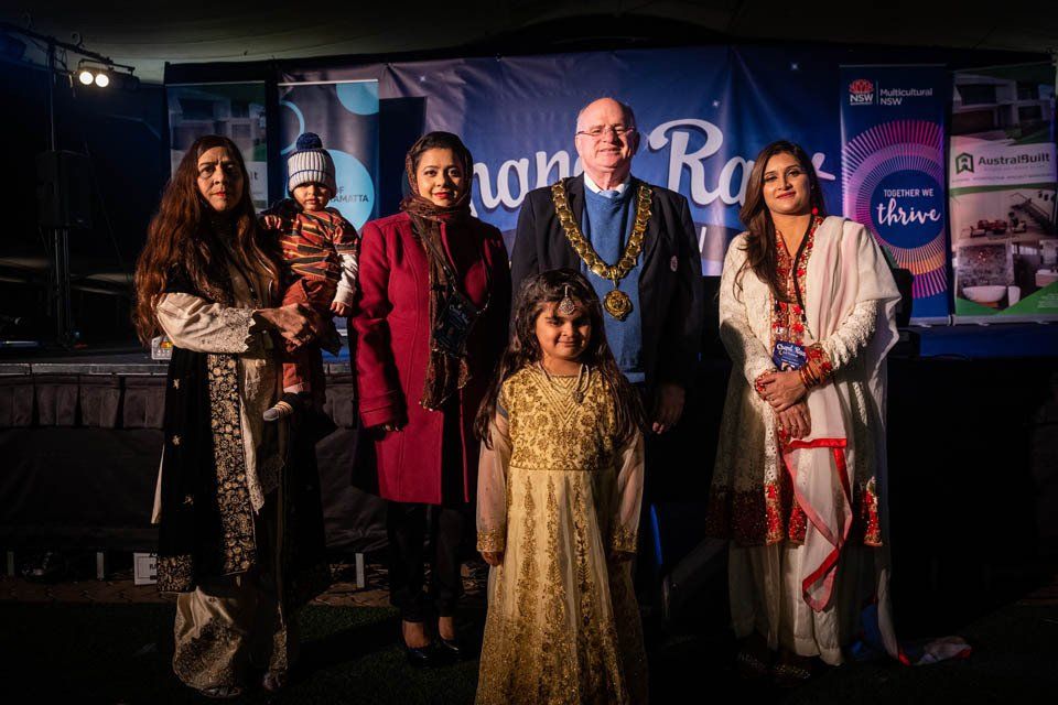 A group of people standing next to each other in front of a stage.