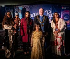 A group of people standing next to each other in front of a stage.