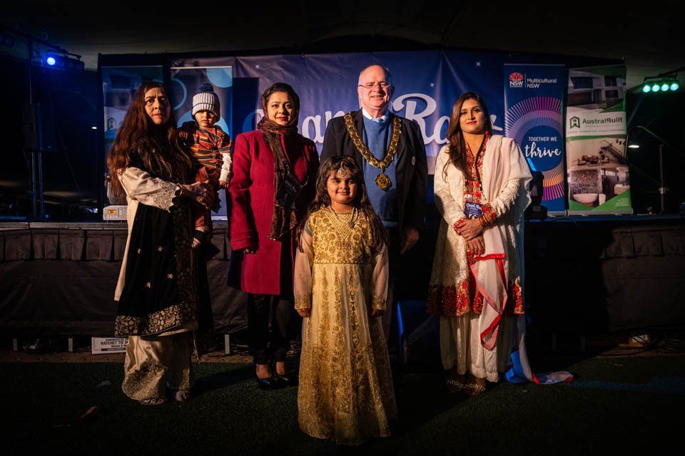 A group of people standing next to each other in front of a stage.