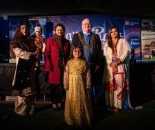 A group of people are posing for a picture in front of a stage.
