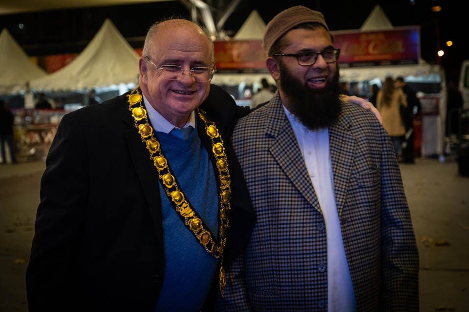 Two men are posing for a picture together and one has a beard.