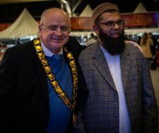 Two men are posing for a picture together and one of them has a beard.