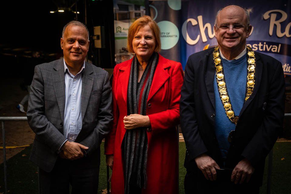 A man in a suit and a woman in a red coat are standing next to each other.