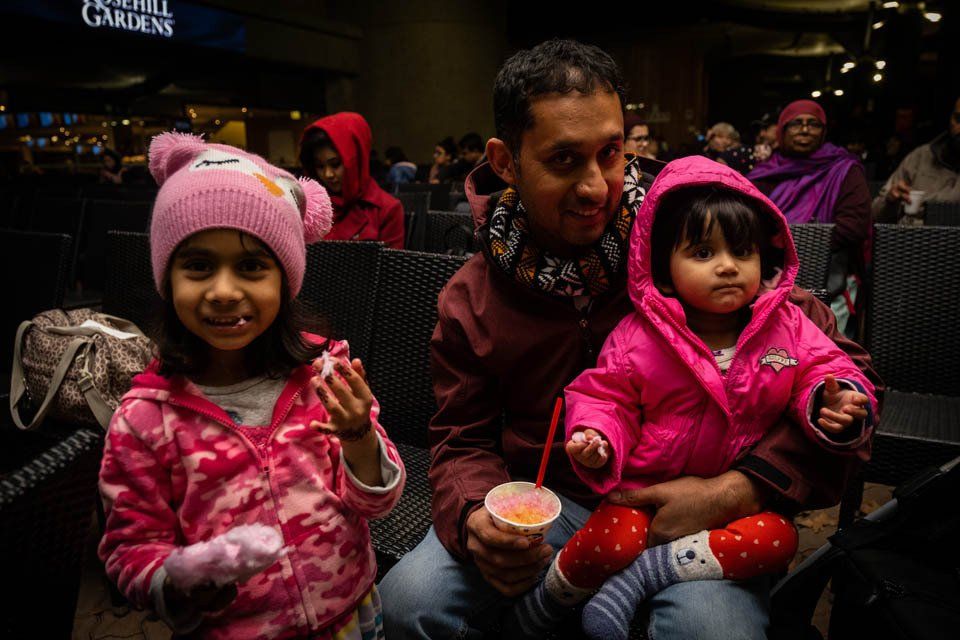 A man is holding two little girls in his arms.