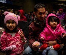 A man is holding two little girls in his arms.