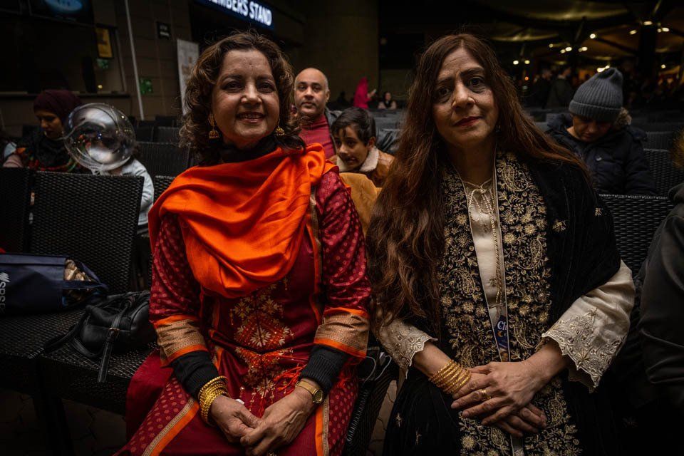 Two women are sitting next to each other in a restaurant.