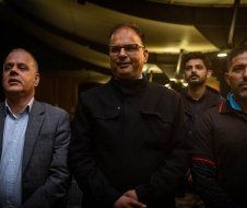 A group of men are standing next to each other in a dark room.