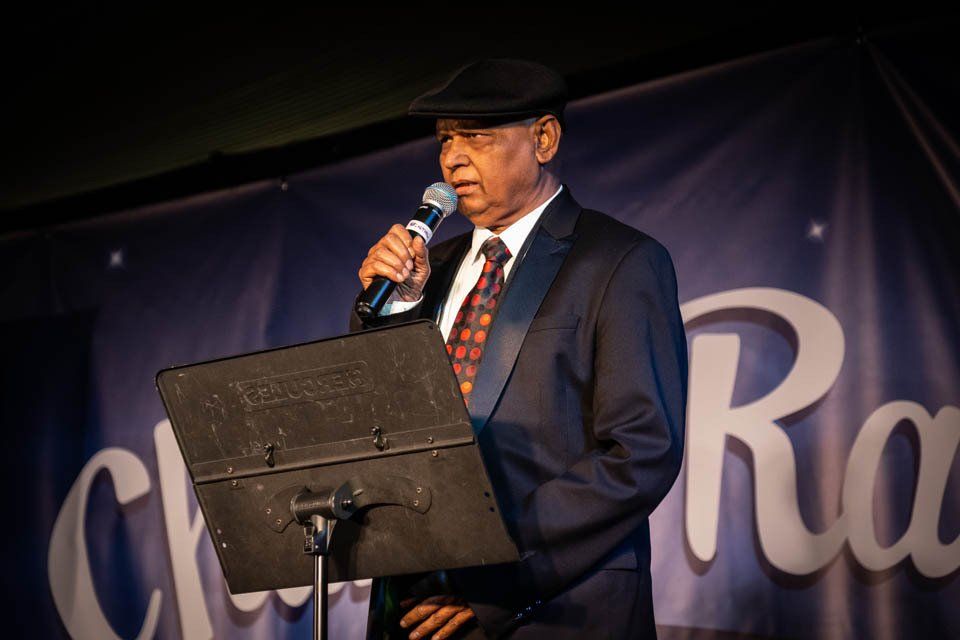 A man in a suit and tie is singing into a microphone.