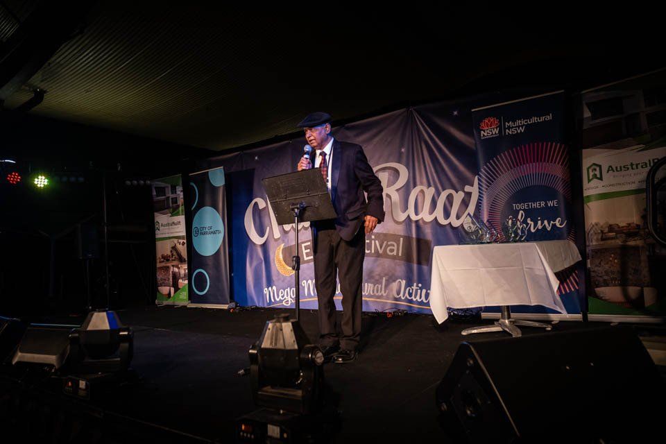 A man is standing on a stage holding a microphone.