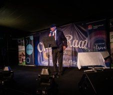 A man is standing on a stage holding a microphone.