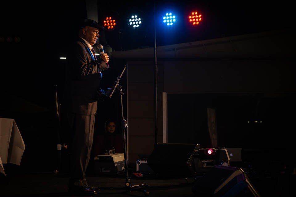 A man is standing on a stage holding a microphone.