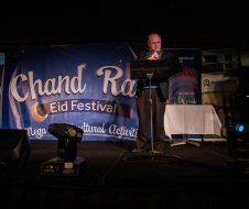 A man is standing in front of a microphone on a stage.