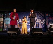 A man and woman are standing next to a little girl on a stage.