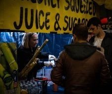 A woman is selling juice and sugar at a market.