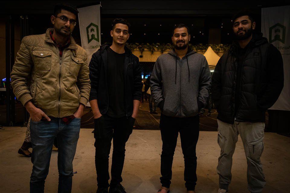 A group of young men are standing next to each other in a dark room.