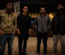 A group of young men are standing next to each other in a dark room.