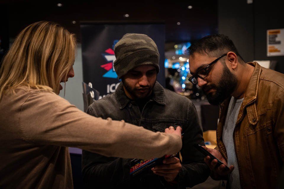 A group of people are looking at a cell phone.