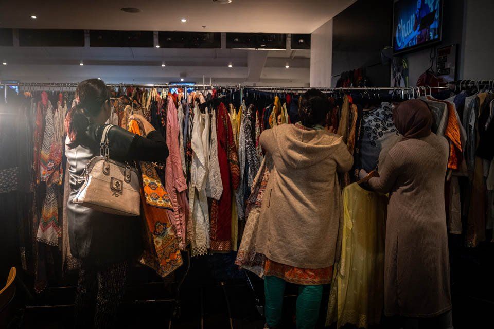 A group of women are shopping for clothes in a store.