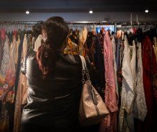 A woman is looking at clothes in a store.
