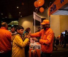 A group of people are standing around a table with balloons.