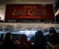 A group of people are standing in front of a restaurant.