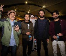 A group of men are standing next to each other in a room.