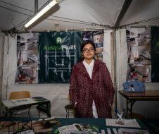 A woman is standing in front of a table in a tent.