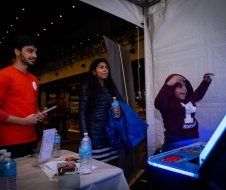A group of people are standing around a table in a tent.
