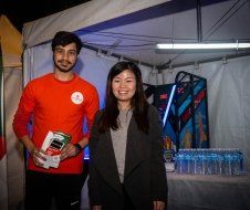 A man and a woman are standing next to each other in front of a tent.
