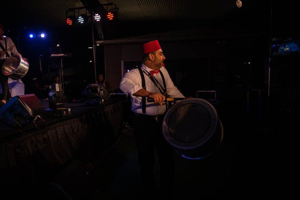 A man is playing drums in a dark room.
