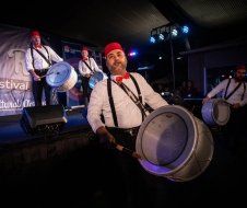 A group of men are playing drums on a stage.