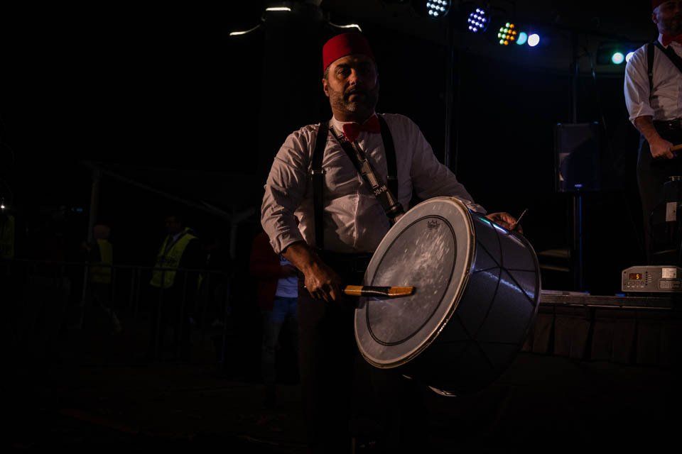 A man is playing a drum in a dark room.