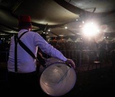 A man is playing a drum in a dark room.