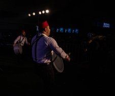 A man is playing a drum in a dark room.