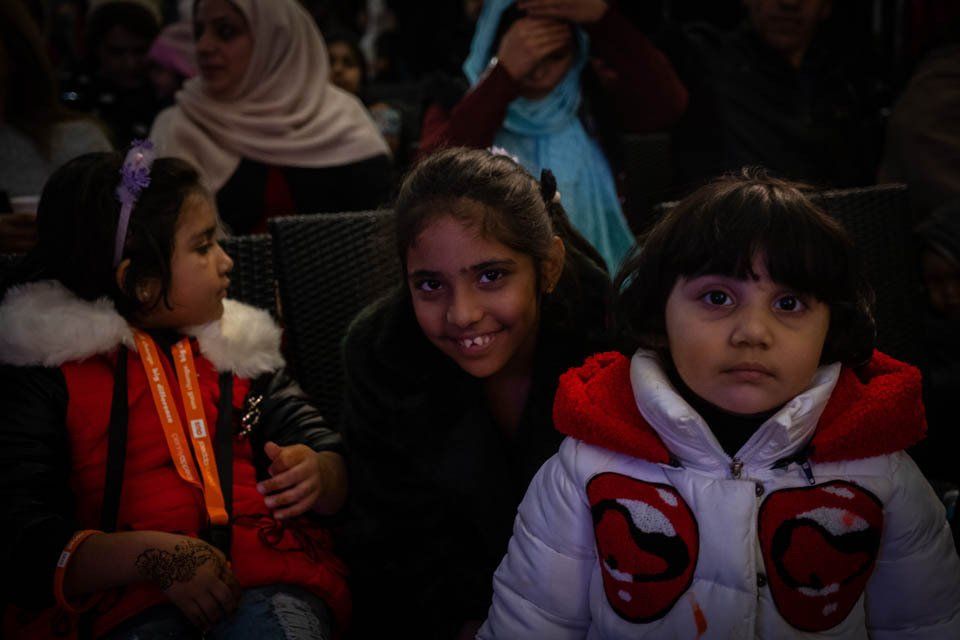 A group of young girls are sitting in a theater.
