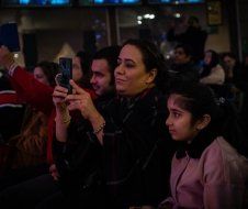 A group of people are sitting in a dark room watching a movie.