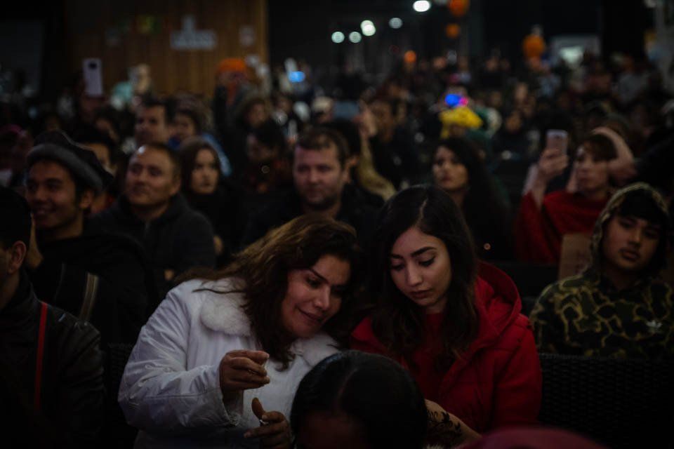 A crowd of people are sitting in a dark room.