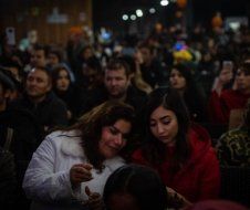 A crowd of people are gathered in a dark room.