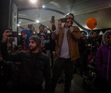 A group of people are taking pictures with their cell phones.