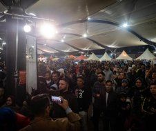 A man is taking a picture of a crowd of people at a festival.