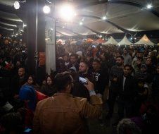 A man is taking a picture of a crowd of people at a festival.