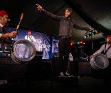 A group of men are playing drums on a stage.