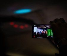 A person is taking a picture of a group of people on a cell phone.